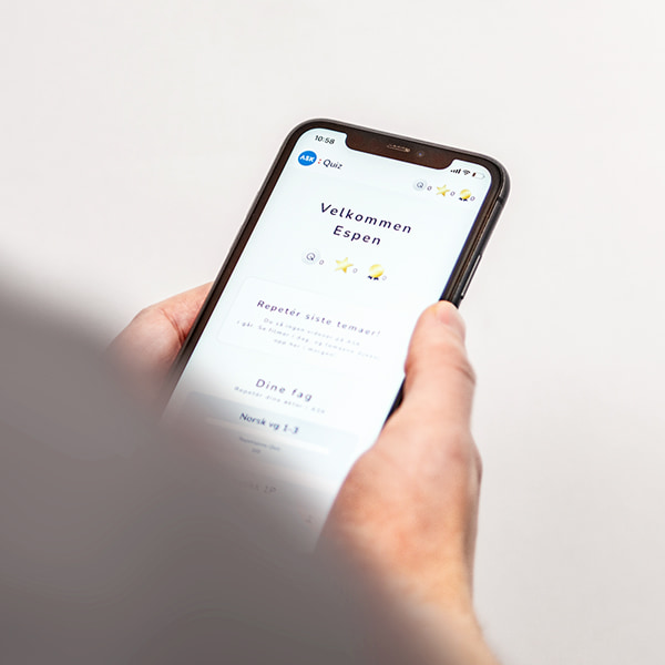 Hånd som holder iPhone med Quiz-app